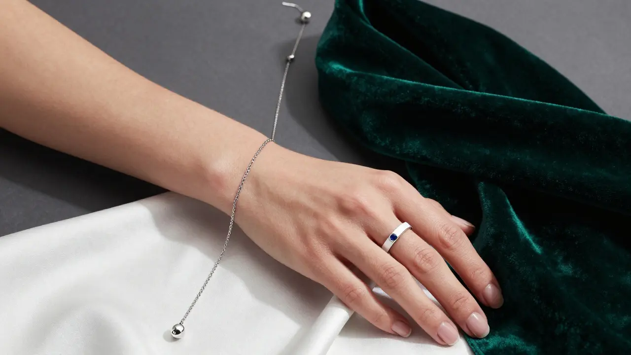 Silver and platinum jewelry displayed on a hand with cool pink undertones
